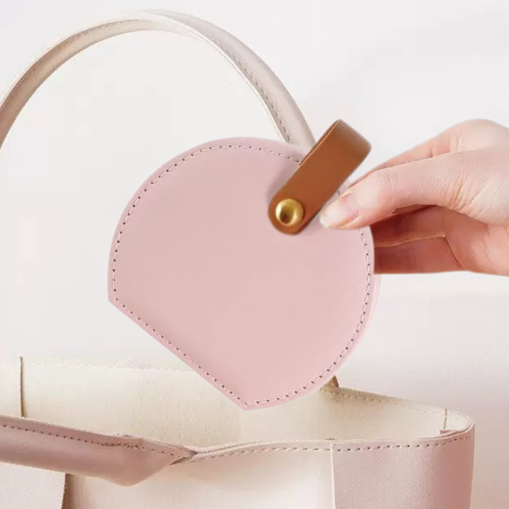 Pink faux leather mini jewellery case being held by models hand