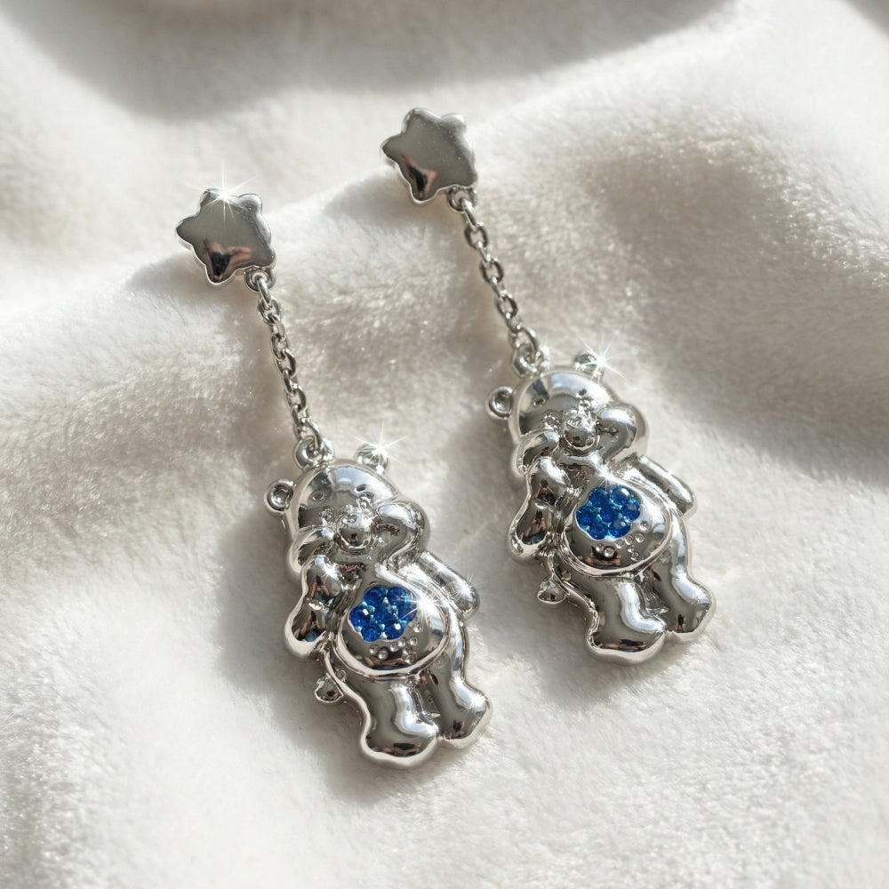 White gold plated Care Bears Grumpy Bear blue Crystal Belly Badge Drop earrings by Couture Kingdom on a white furry background