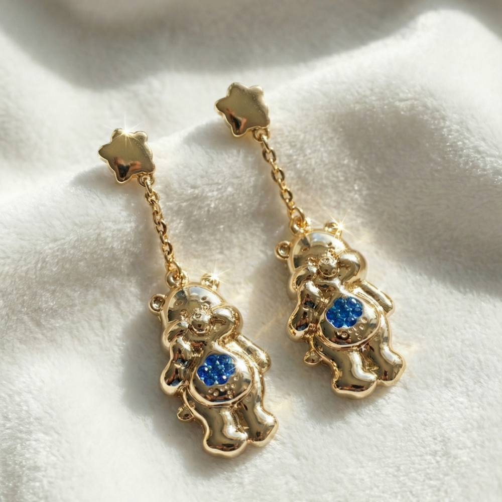 Yellow gold plated Care Bears Grumpy Bear blue Crystal Belly Badge Drop earrings by Couture Kingdom on a white furry fabric background