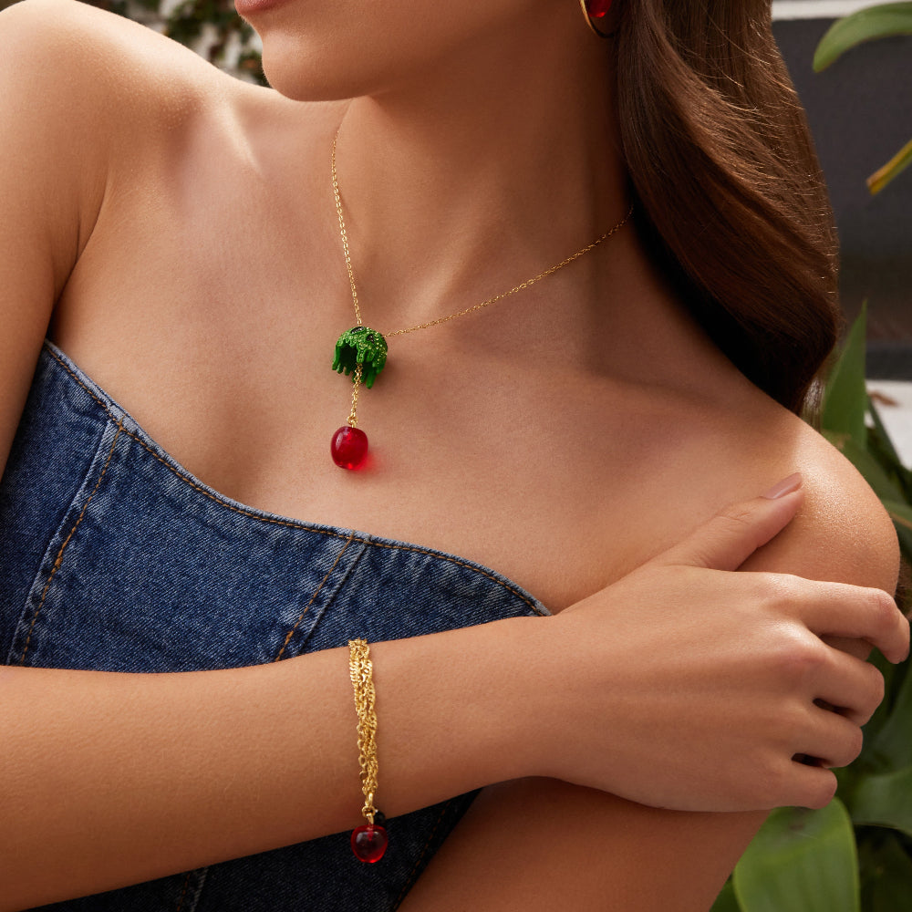Yellow Gold Plated Snow White Poison Apple necklace by Couture Kingdom worn on model with denim strapless top