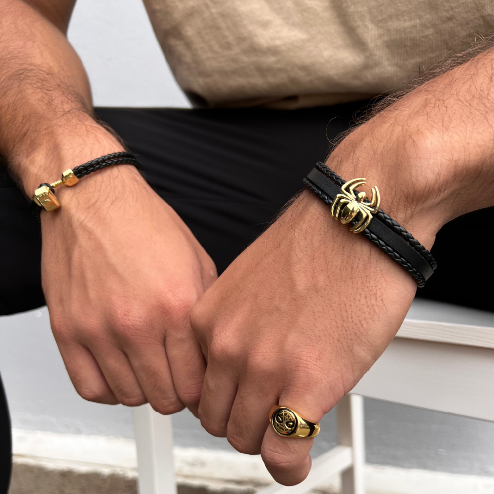 Marvel braided Leather bracelet with gold plated Thor Hammer worn on male wrist with other wrist wearing a leather Marvel Spider Man bracelet and gold plated spider man ring by couture kingdom